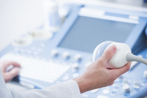young woman doctor's hands close up preparing for an ultrasound device scan.